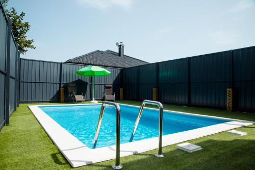 Sanski mostMILUX的一个带围栏和遮阳伞的游泳池
