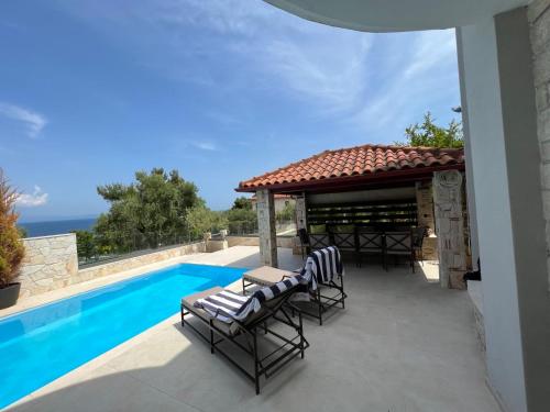 克里皮吉Sunny Seaside Villa-90 m from beach的一个带椅子的庭院和一个池畔凉亭