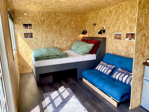 SkibbyCozy Tiny House on a farm的小房间设有床和沙发