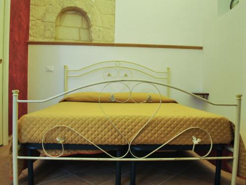 卡斯泰拉内塔B&B LuiRò的一张带黄色棉被的金属框架床