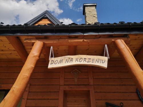 Dom Na Korzeniu的悬挂在小屋上的标志