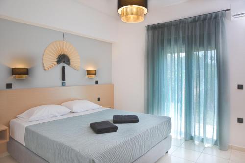 蒂加基Philippos & Alexandros Apartments的一间卧室设有一张大床和一个大窗户