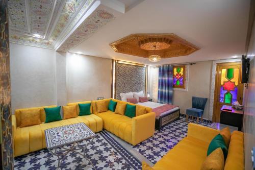 非斯Hotel & Ryad DALILA的客厅配有黄色的沙发和床。