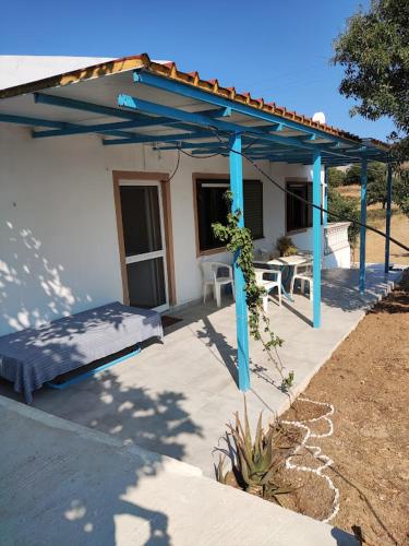 伊利达Kea Guesthouse的一个带蓝色凉亭和一张床的庭院
