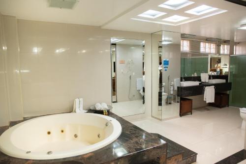 卡鲁阿鲁帕里姆卡鲁阿鲁村酒店的大型浴室设有浴缸和淋浴。