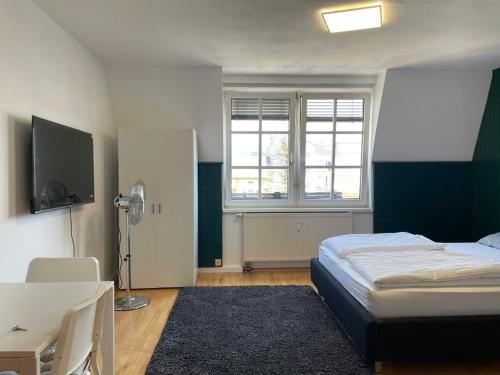 林茨Linz -central condo的一间卧室配有一张床、一张书桌和一台电视。