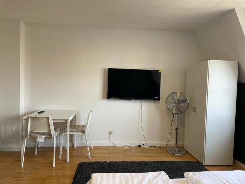 林茨Linz -central condo的客厅配有桌子和墙上的电视