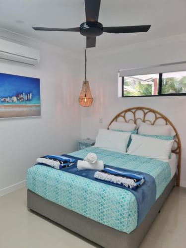 三一海滩Blue Lagoon Tropical Sanctuary的一间卧室配有一张大床和风扇