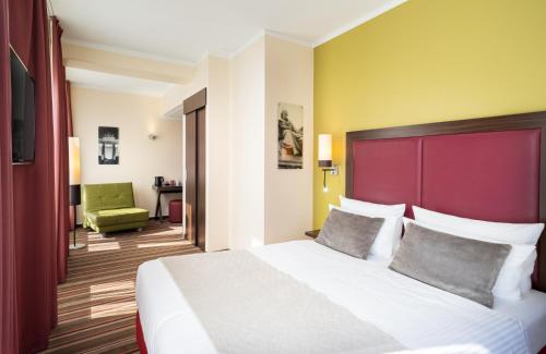 柏林柏灵莱昂纳多酒店的一间卧室配有一张大床和红色床头板