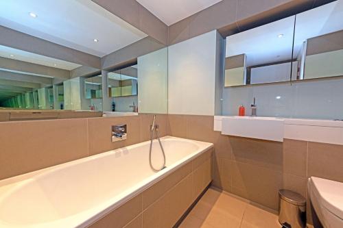 伦敦伦敦市中心舒适公寓的带浴缸和盥洗盆的大浴室