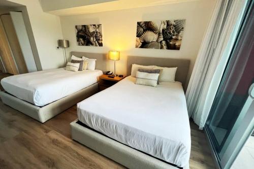 哈兰代尔海滩Beautiful studio in Hallandale Beach的酒店客房设有两张床和窗户。
