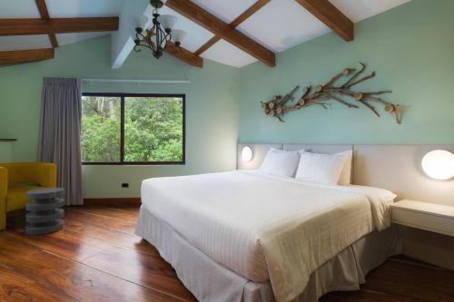 蒙泰韦尔德哥斯达黎加Koora Monteverde-a Cloud Forest Hotel by Sandglass的卧室设有一张白色大床和一扇窗户。