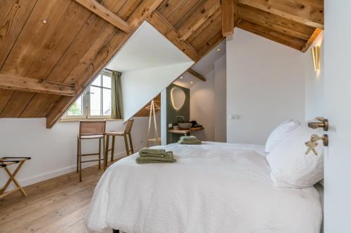 雷讷瑟Fika的卧室设有白色的床和木制天花板。