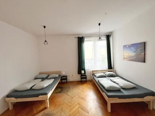 克拉科夫Nice View Rooms In Old Town的带窗户的客房内设有两张单人床。
