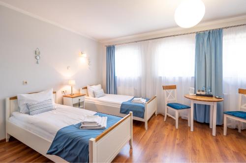 MinikowoHotel Rozmaryn i Lawenda的酒店客房设有两张床和一张桌子。