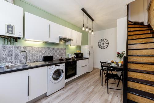 利布尔讷- Le P'tit nid -的厨房配有洗衣机和桌子