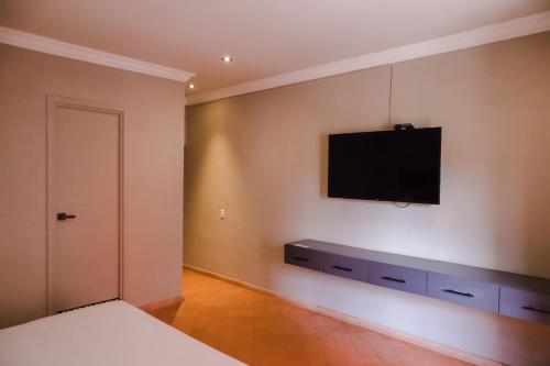 圣米格尔-德阿连德Mikaella Hotel的卧室设有壁挂式电视和床。