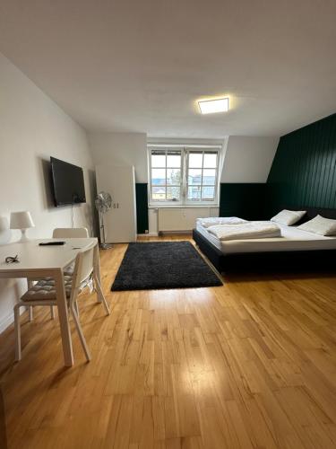 林茨Linz -central condo的一间卧室配有一张床、一张桌子和一张桌子