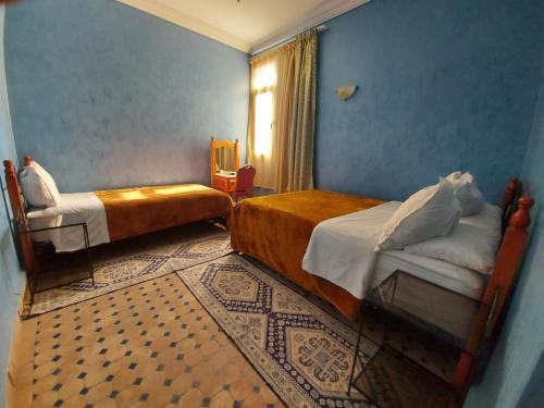 瓦尔扎扎特玛尔玛酒店的一间卧室设有两张床和窗户。