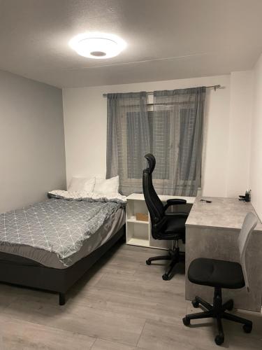 诺尔雪平Central Apartment with 3 bedrooms的一间卧室配有一张床、一张桌子和一把椅子