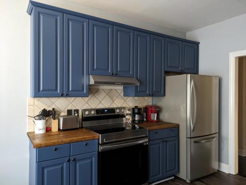 哥伦比亚The Elizabeth的厨房配有蓝色橱柜和不锈钢冰箱