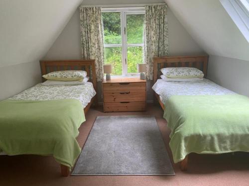 达特茅斯Watermill Cottages - 18th Century converted Mill 10 mins from beach的阁楼卧室设有两张床和窗户。