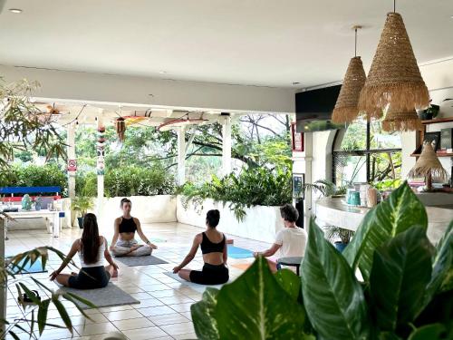 塔马林多Zulu Surf Hotel Tamarindo的一群坐在房间做瑜伽的人