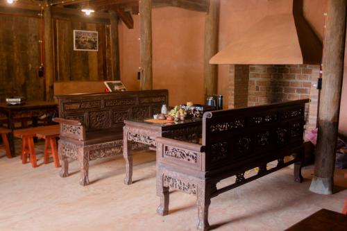 同文Dinh Đá H'Mông - Karsterly Rock Lodge的一间设有两套桌子和一架钢琴的房间