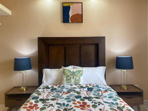 佩尼亚斯科港Ancla Suite 2 - 2 Bedroom Urban Hotel的一间卧室配有一张带两张台灯的床铺。