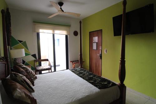 瓜达拉哈拉Ekléctic Hotel Boutique的一间卧室配有一张床和吊扇