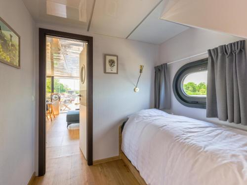 厄伊特海斯特Tiny Houseboat De Woudaap - I的卧室配有白色的床和窗户。