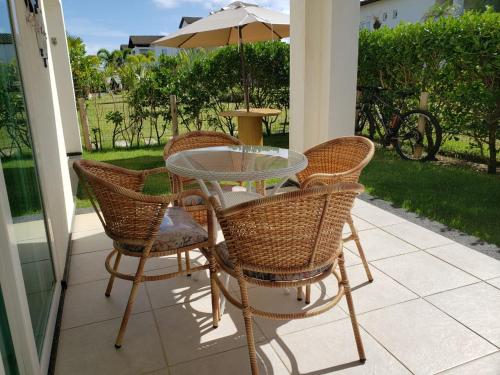 Entre RiosApartamento Particular de 03 suítes, Resort Treebies, Praia de Subauma - Ba的露台上的桌椅和遮阳伞