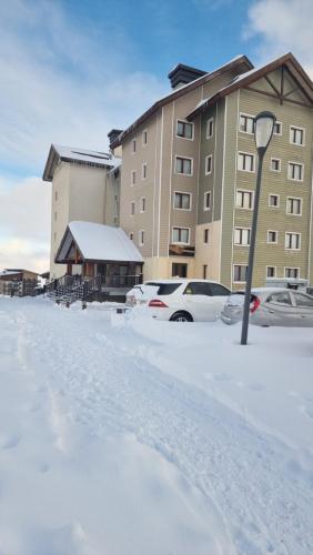 圣地亚哥Departamento Valle Nevado, Ski in - Ski out的大楼前的雪地停车场