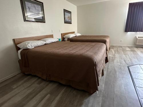 洛杉矶快乐罗杰酒店的配有2张床的酒店客房,铺有木地板