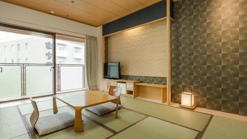 神户Diamond Arima Onsen Society的客厅配有桌子和电视