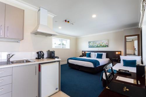 Tuakau图阿栲酒店的一间厨房和一间带一张床的卧室