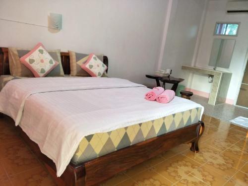 色军Alongkon Mansion的一间卧室配有一张粉红色弓床