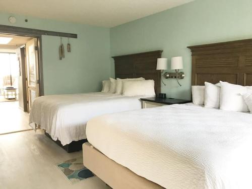 默特尔比奇Flip Flop at Compass Cove的配有白色床单的酒店客房内的两张床