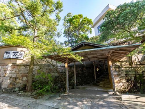 白滨Tabist Nanki Shirahama Ryokan Mantei的石墙房屋的木门