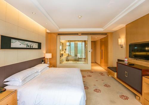 无锡无锡富力喜来登酒店的一间卧室配有一张大床和一台平面电视