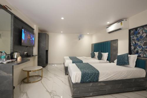纳威孟买MEGH INN的酒店客房设有两张床和一台平面电视。
