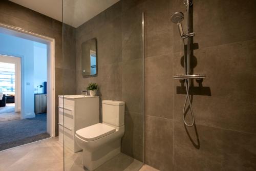 普雷斯顿Preston Apartments的一间带卫生间和玻璃淋浴间的浴室