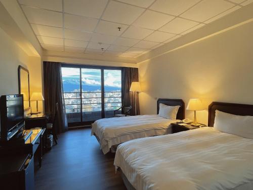 斗六市華安大飯店的酒店客房设有两张床和大窗户。