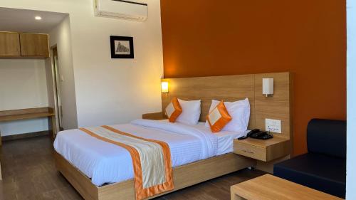 克久拉霍Hotel The Bundela - Khajuraho, Madhya Pradesh的酒店客房,配有一张橙色墙壁的床