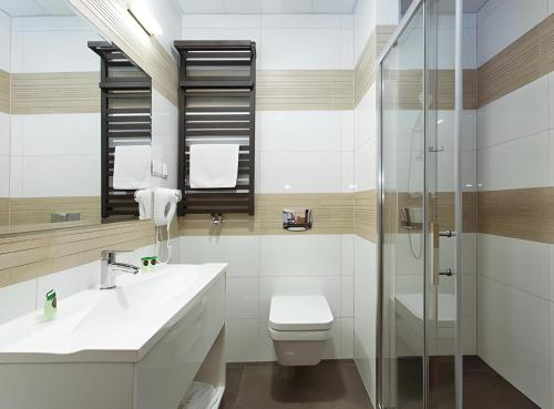 JesionkaHotel Tanzanit的浴室配有卫生间、盥洗盆和淋浴。