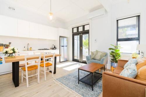 悉尼Crows Nest LemonTree Cozy 3 Bedroom House的厨房以及带桌子和沙发的客厅。