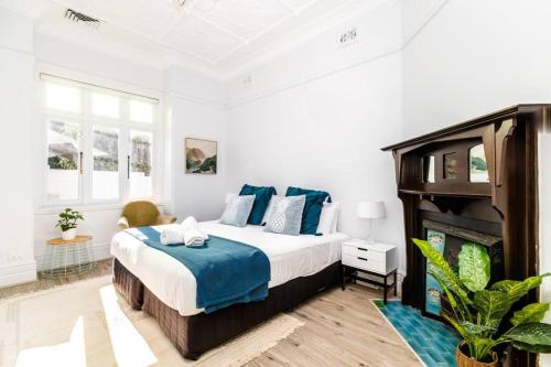悉尼Crows Nest LemonTree Cozy 3 Bedroom House的一间卧室设有一张大床和一个壁炉