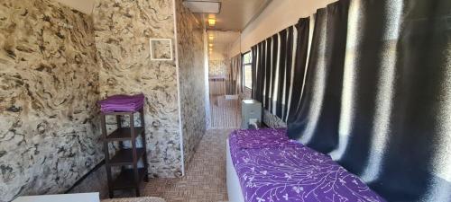 南埃福列CASE MOBILE (CASE IN NATURA)的小房间设有紫色的床和石墙