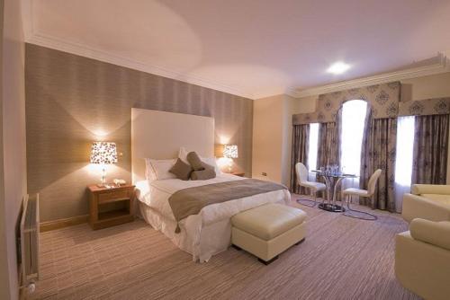 戈特Lady Gregory Hotel, Leisure Club & Beauty Rooms的卧室配有一张床和一张桌子及椅子