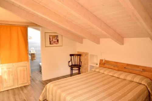 阿尔盖罗PM Villa Tania Guest House的一间卧室,卧室内配有一张床和一把椅子